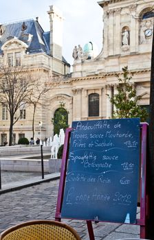 Black board with a menu restaurant in a tipical traditional square in Paris
