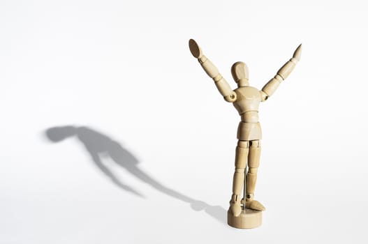 Happy wooden mannequin with sad shadow isolated in white background.