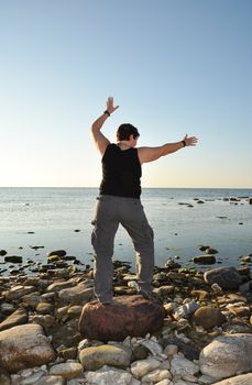Woman doing tai chi by the sea.
