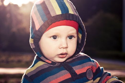 Cheerful boy in the hood in nature.