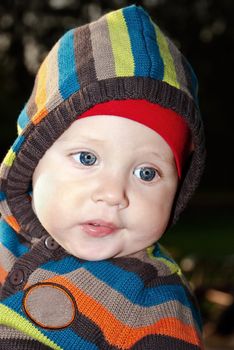 Portrait of a cute boy in the hood with beautiful blue eyes.