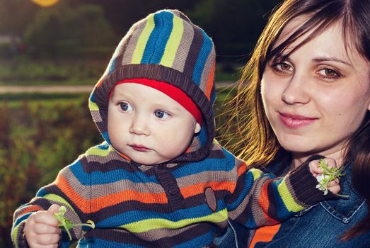 Happy mother with her son in her arms in the park.