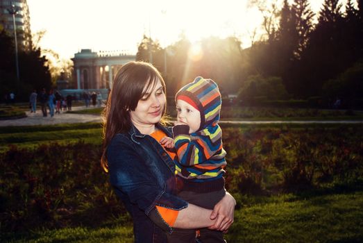 Happy mother with her child in her arms in the park.