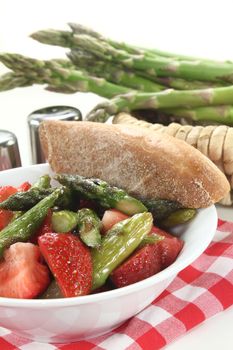 a bowl of asparagus strawberry salad with roasted green asparagus