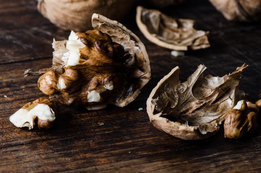 Close up cracked walnuts on dark wooden table