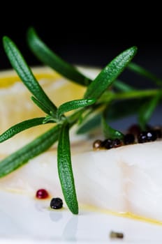 Raw fish with herbs and lemon close up