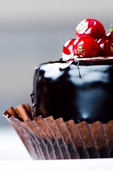 Chocolate cake with redcurrants on white saucer