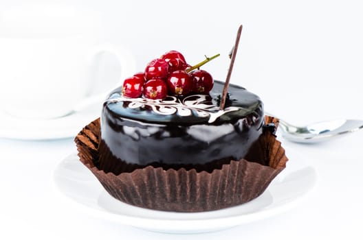 Chocolate cake with redcurrants on white background