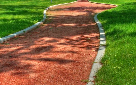 winding alley and beautiful spring grass in the park