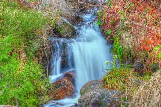 beautiful waterfall from melting snow up in the mountains in spring