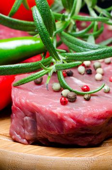 Raw beef steak on wooden board close up