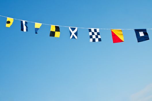 Nautical flags against blue sky