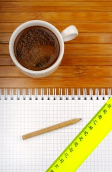 notebook pencil line and coffee on a wooden background