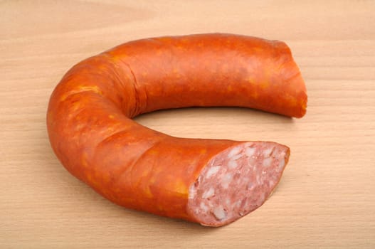 smoked sausage in natural casing on wooden background