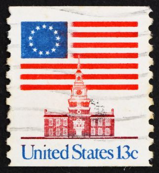 UNITED STATES OF AMERICA - CIRCA 1975: a stamp printed in the USA shows 13-Star Flag and Independence Hall, circa 1975