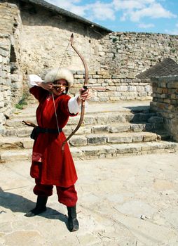 Beautiful young girl with bow and arrows in medieval costume