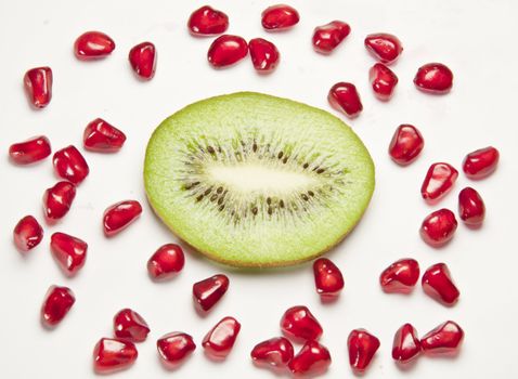 kiwi and pomegranate grains on white background
