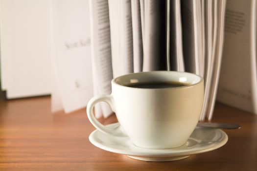 Coffee and books on a wooden table. Small depth of sharpness.