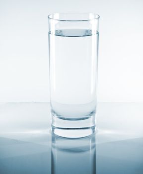 Glass of water on a reflective table top