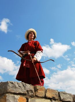 Beautiful girl with bow and arrows on blue sky background