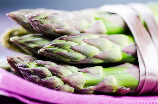 Bunch of asparagus on purple napkin