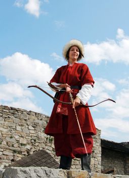 Beautiful girl with bow and arrows on blue sky background