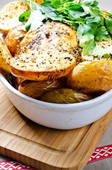 Oven baked potato with pasley on wooden cutting board