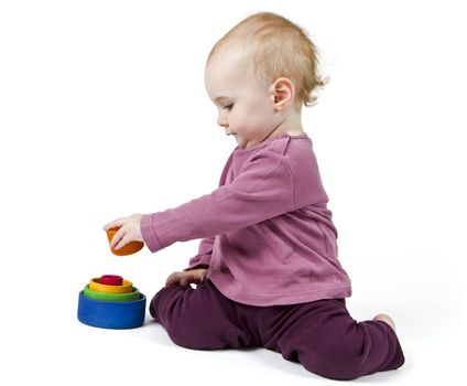 young child playing with colorful toy blocks in white background
