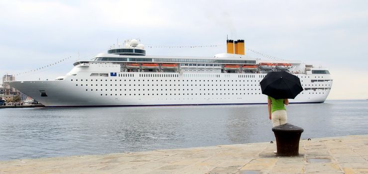 Young woman and big cruiser on the sea.