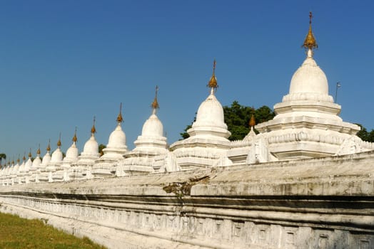 Row of historic white buddhist stupa in Myanmar