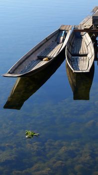 Wooden boats with mirror in clear water