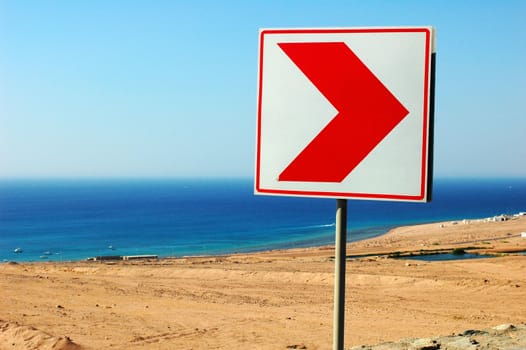 Right direction road sign on the beach