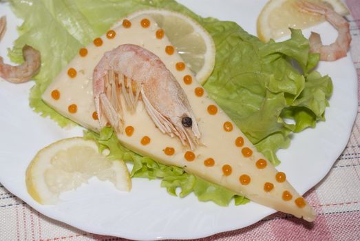 Sea shrimp on cheese with red caviar of a salmon and leaves of green salad .Restaurant background