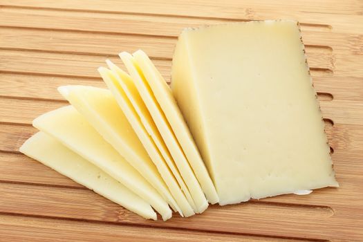  table of cut with wedge of cheese cut partially sliced