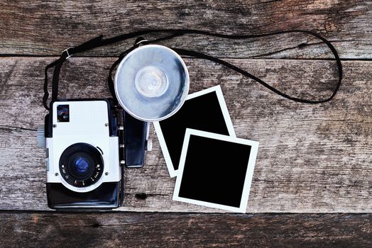 Vintage camera with blank photos on a rustic background. Clipping path in photos included.
