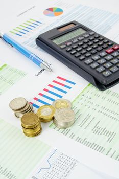 Calculator, pen, coins on a colorful business background