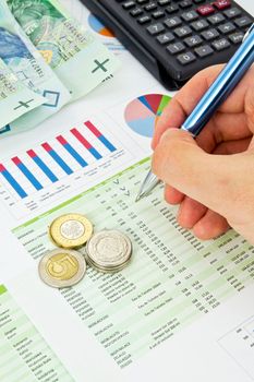 Calculator, pen, coins on a colorful business background