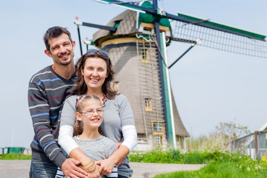 Family of three near windmill in Holland