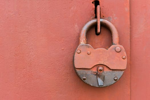 Old big lock on red metal door