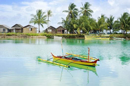 Tropical landscape with traditional Philippines boats and village on Calicoan island, Philippines