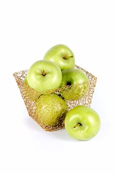 Green celebratory apples lie in a gold basket on a white background