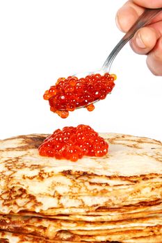 Pile of pancakes on a plate on a white background with a spoon of red caviar
