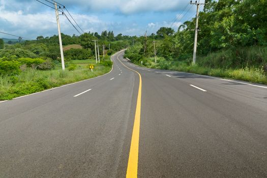 Yellow curve line on the road toward the mountain