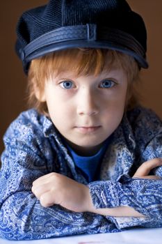 portrait of a handsome boy in a blue shirt and cap