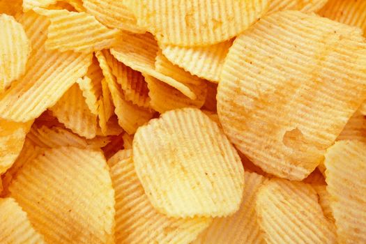 Golden potato chips background, closeup studio shot