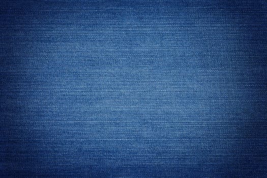 Blue denim background, detailed texture with vignette