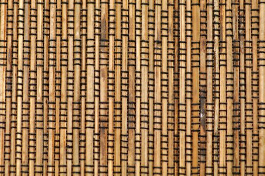 Bamboo mat with black thread closeup as background