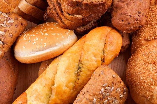 Arrangement of baked bread and rolls closeup on wooden background