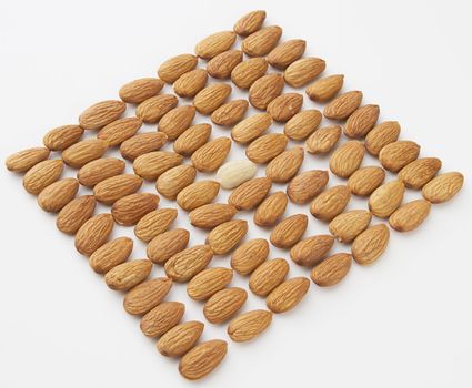 almond put in a row with one peeled almond in the middle