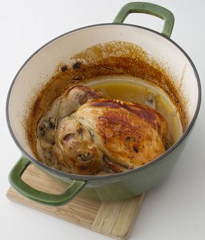 roasted chicken sitting in a cooking pot